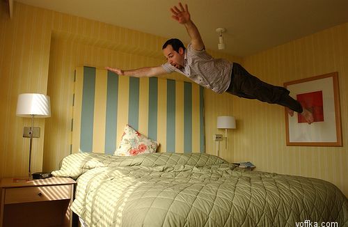 Упала на постель. Человек прыгает на кровати. Падает на кровать. Мужчина прыгает на кровати.